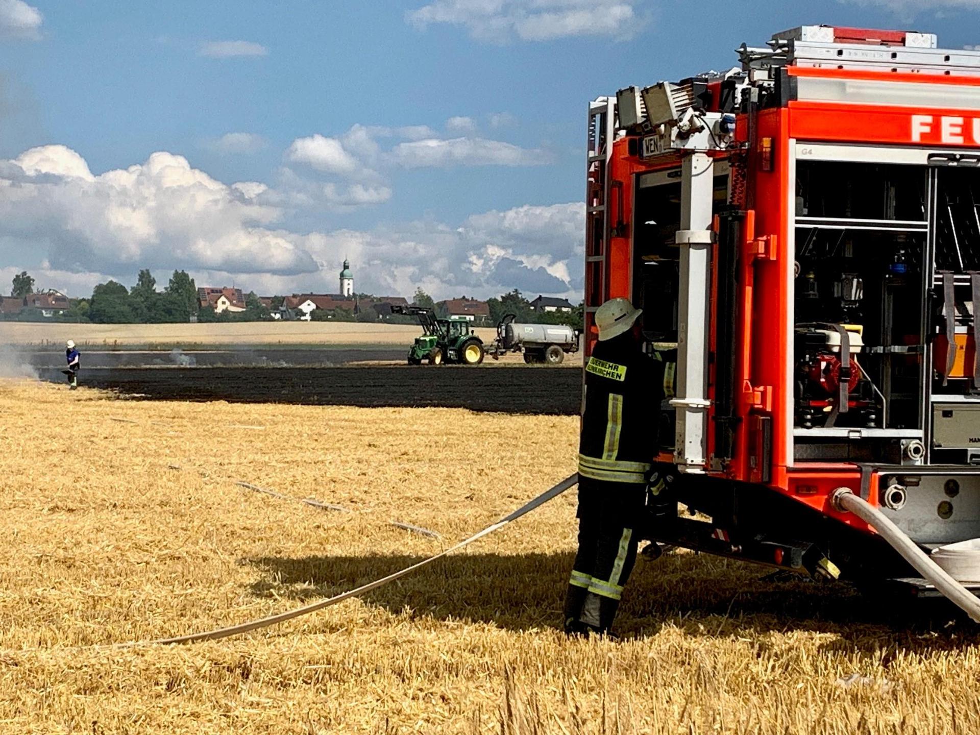Die Feuerwehr löscht einen Feldbrand in Neunkirchen bei Weiden. Landwirte schaffen Löschwasser in Güllefässern heran. (Bild: Gabi Schönberger)