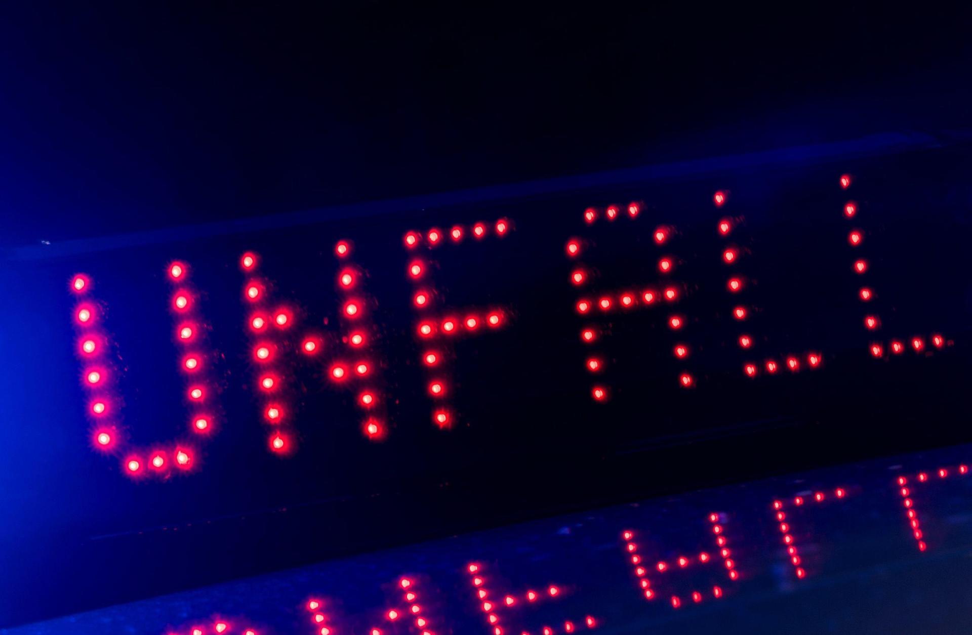Das Blaulicht auf einem Fahrzeug der Polizei leuchtet in der Dunkelheit, während auf dem Display der Hinweis «Unfall» zu lesen ist. (Archivbild: Monika Skolimowska)