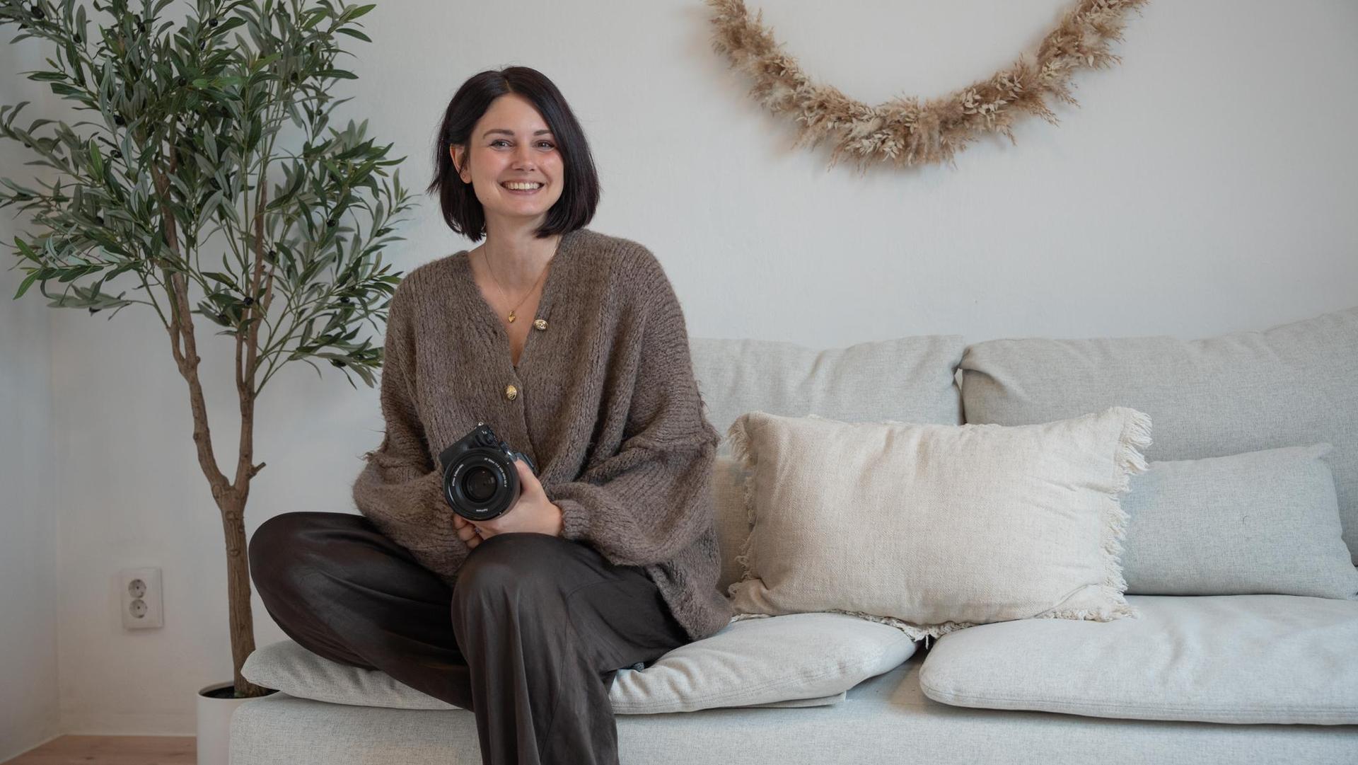 Cassandra Bscherer sitzt in ihrem Studio in Pressath. Seit 2024 hält sie hauptberuflich Erinnerungen aus besonderen Lebensphasen fest. Für sie ist es ihr „absoluter Traumjob”. (Bild: Annalena Rubey)
