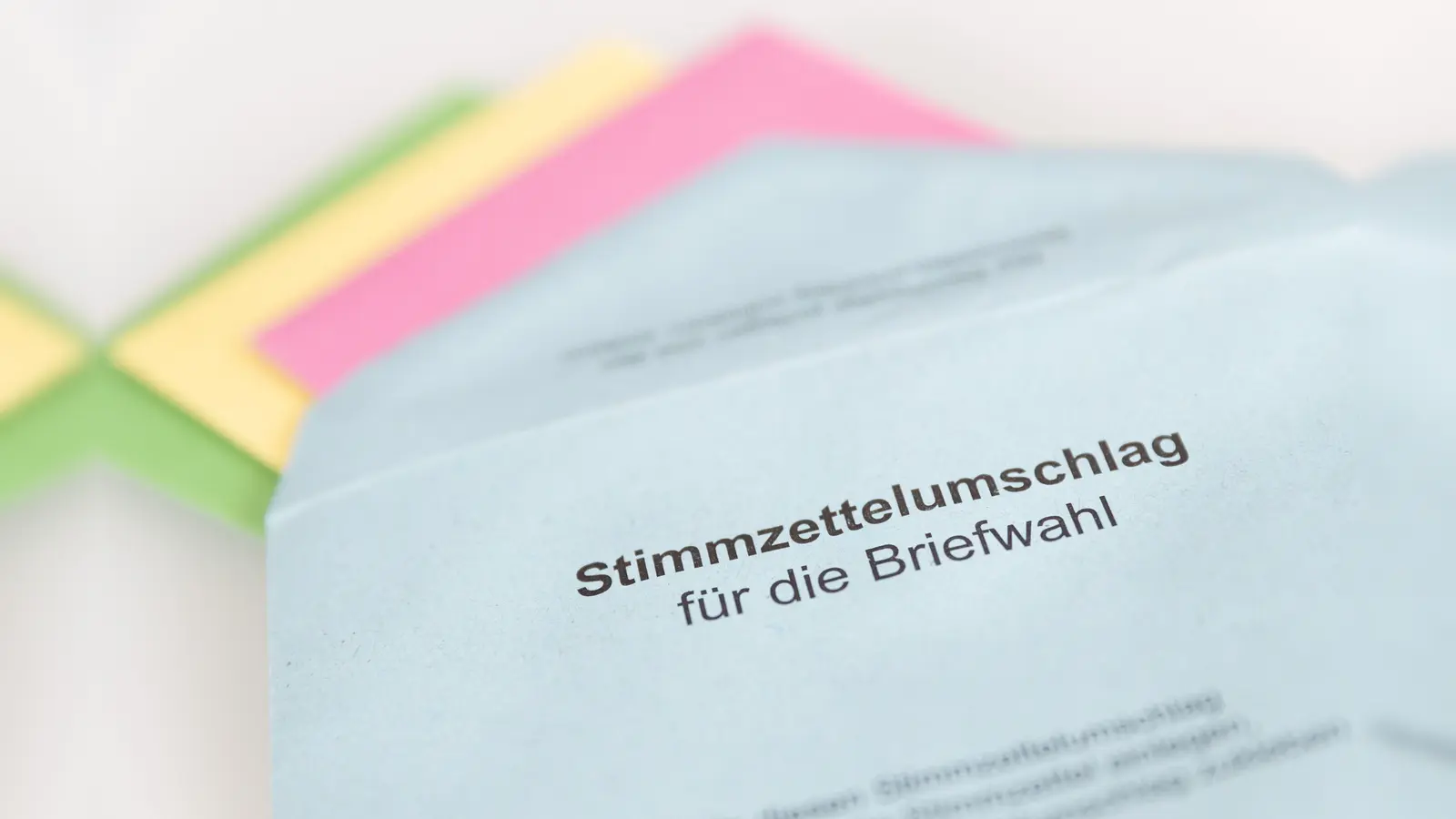 Verschiedene Stimmzettel stecken in einem Stimmzettelumschlag für die Briefwahl.  (Bild: Friso Gentsch/dpa)