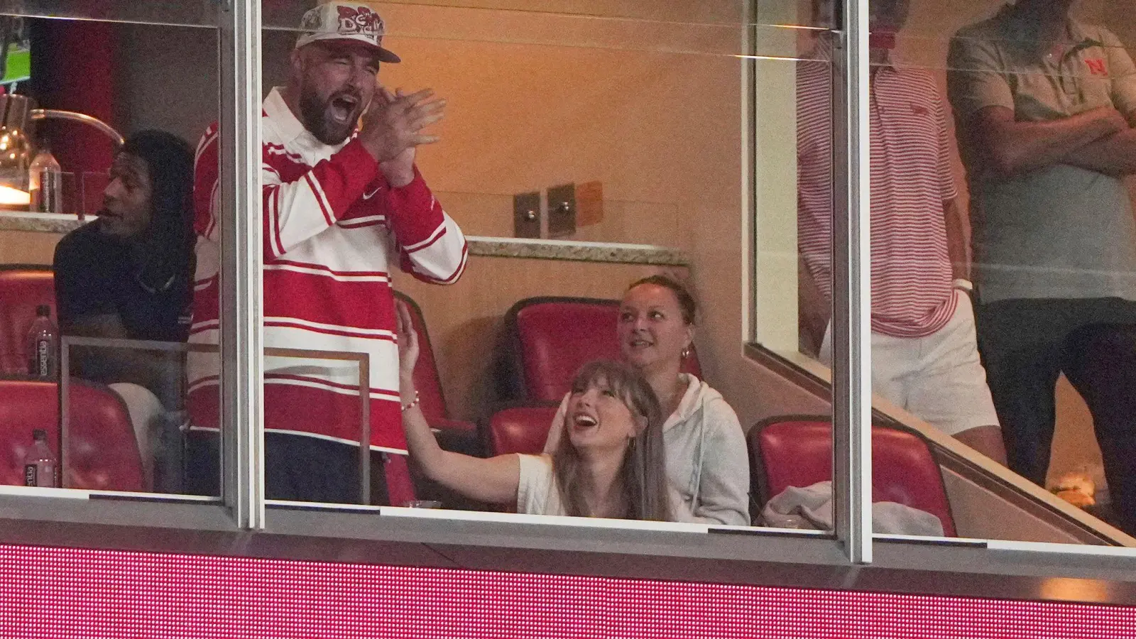 Er jubelt, sie wirft ihm einen verliebten Blick zu: Travis Kelce und Taylor Swift bei einem College-Football-Spiel. (Bild: Charlie Riedel/AP/dpa)