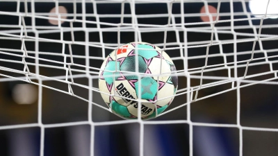Ein Fußball liegt vor der Partie im Netz. (Bild: Friso Gentsch/dpa/Symbolbild)
