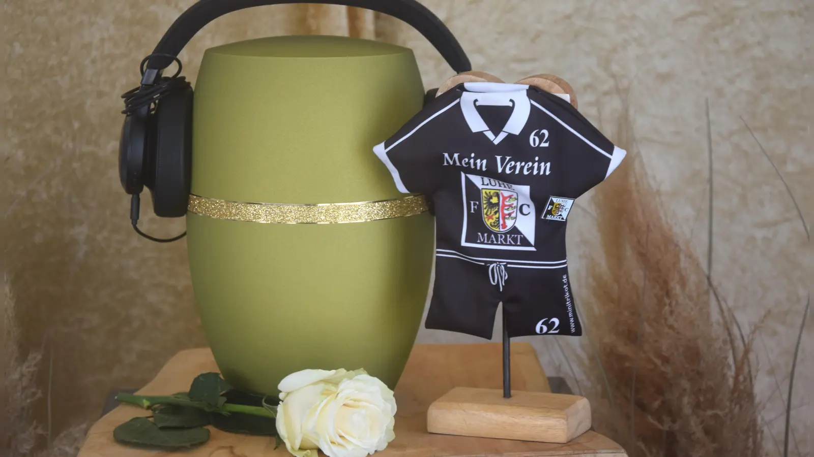 Die Urne mit den Kopfhörern von DJ Easy und das Banner seines geliebten FC Luhe. (Bild: Ernst Frischholz)