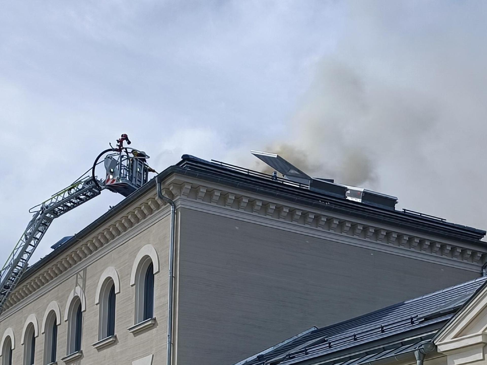 Von der Drehleiter aus soll der Brand auf dem Wiesauer Bahnhofsgebäude bekämpft werden. (Bild: nic)