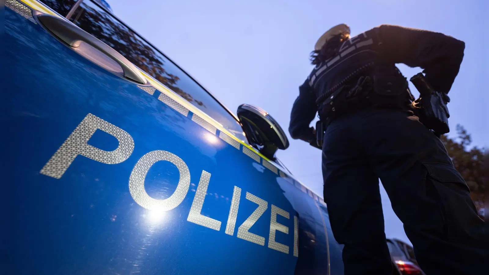Polizisten fordern den Mann mehrere Male auf, von der Fassade wieder herunterzuklettern. (Symbolbild) (Bild: Marijan Murat/dpa)