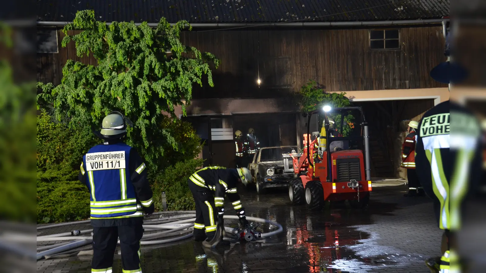 Mit schwerem Atemschutz rückten die Einsatzkräfte der Feuerwehr vor, um das verbrannte Fahrzeug aus der Garage zu ziehen. (Bild: dob)
