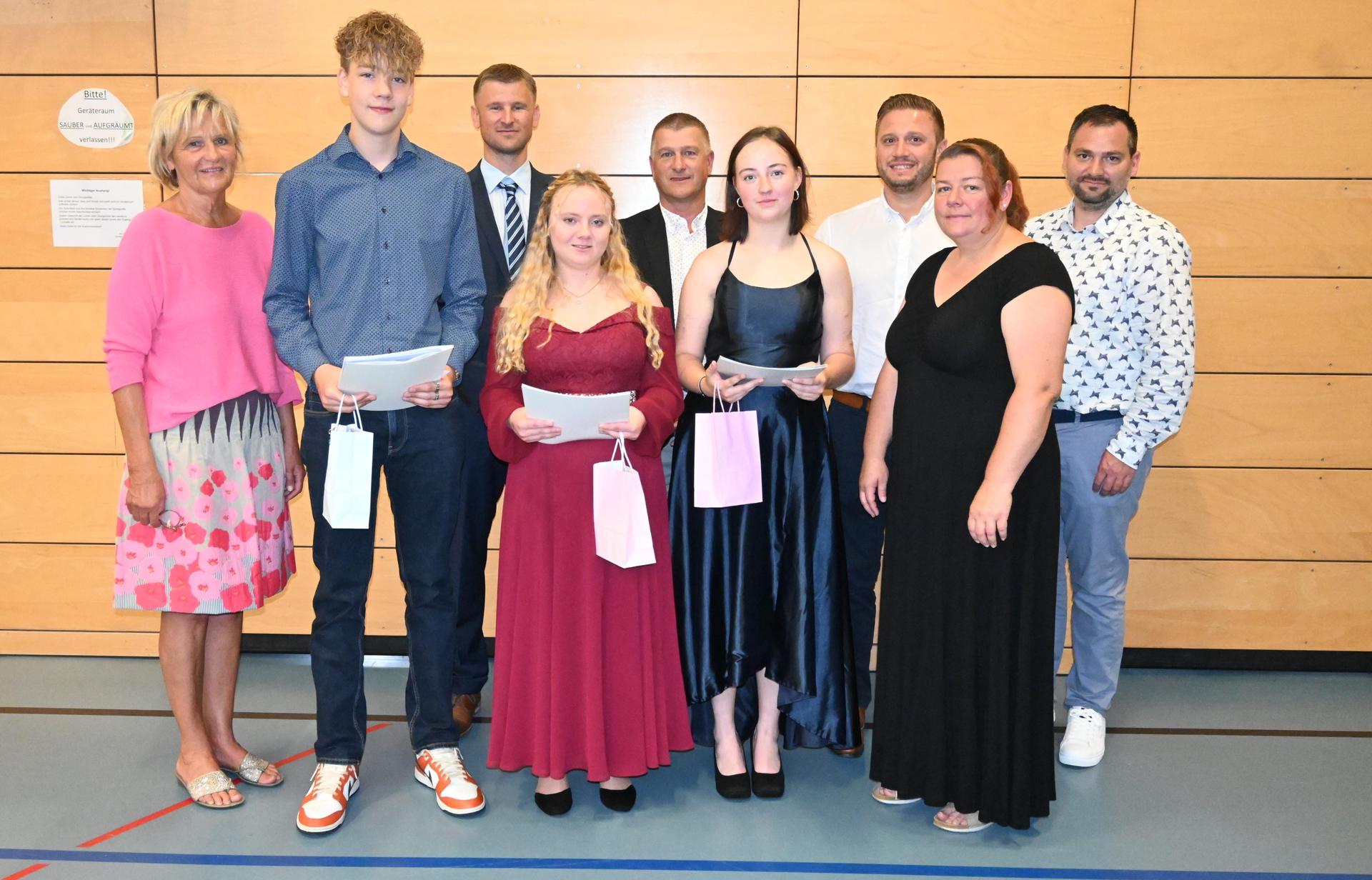 Rektorin Claudia Piehler gratuliert Tobias Laufmann, Selina Bernhardt und Sophia Donatello zusammen mit Elternbeiratsvorsitzender Nicole Bauer (vorne, von links), Klassenleiter Matthias Werner, Bürgermeister Dietmar Schaller und den Kollegen Ernst Lenk und Sebastian Hartl (hinten, von links). (Bild: Kiener/exb)
